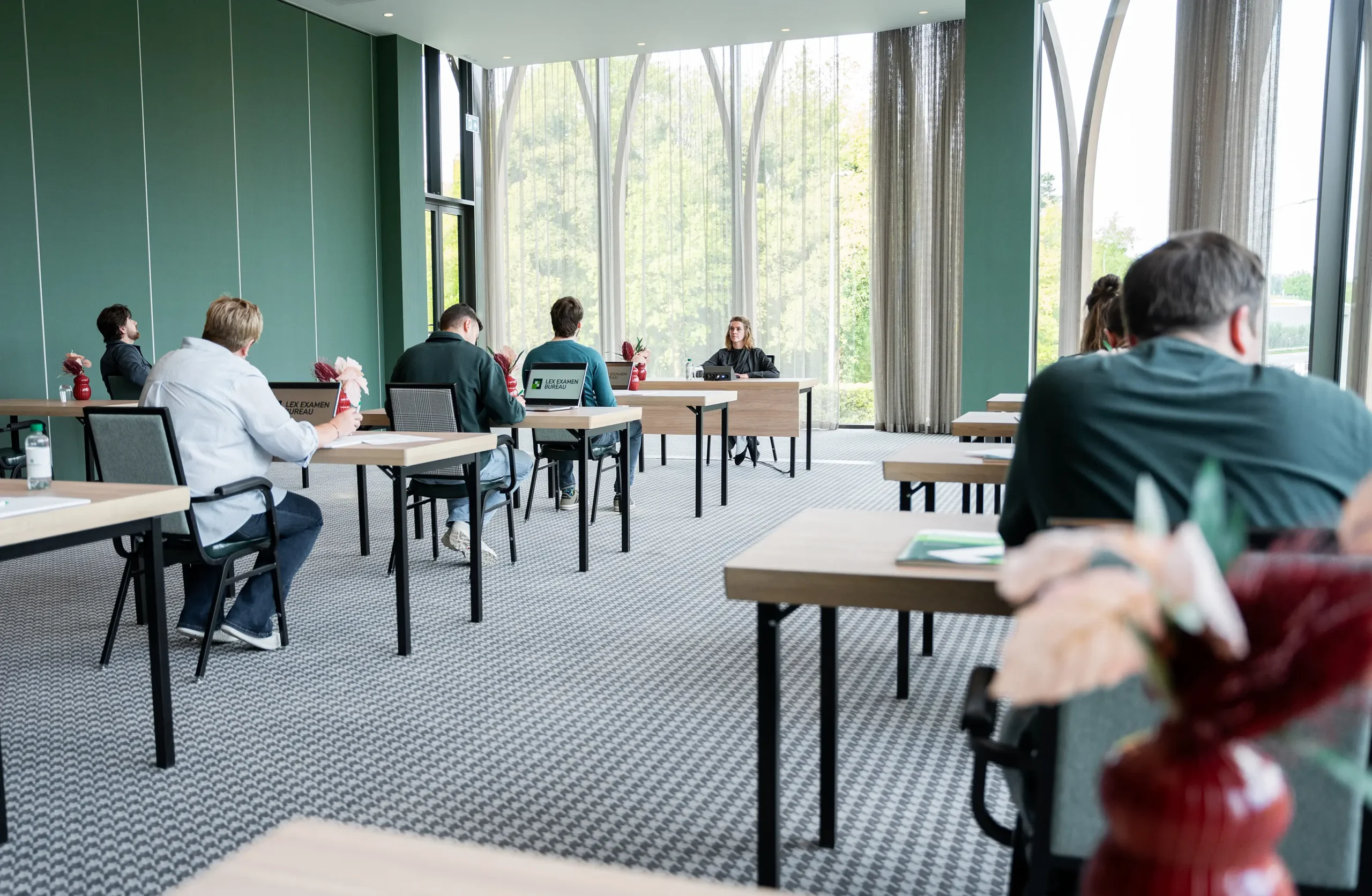 Ruimte met mensen die examen doen die kijken naar de examinator
